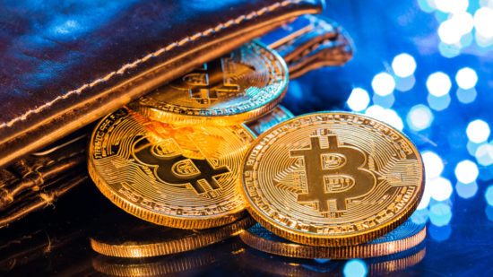 Bitcoin gold coins with wallet, close-up Virtual cryptocurrency concept